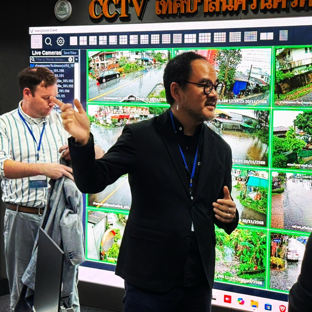A city operations centre in Nakhon Si Thammarat: a wall of CCTV feeds, and a man explaining it to visitors